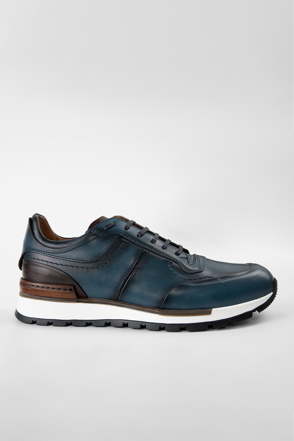 A blue leather runner shoe with triple stitching and a patina effect finish.