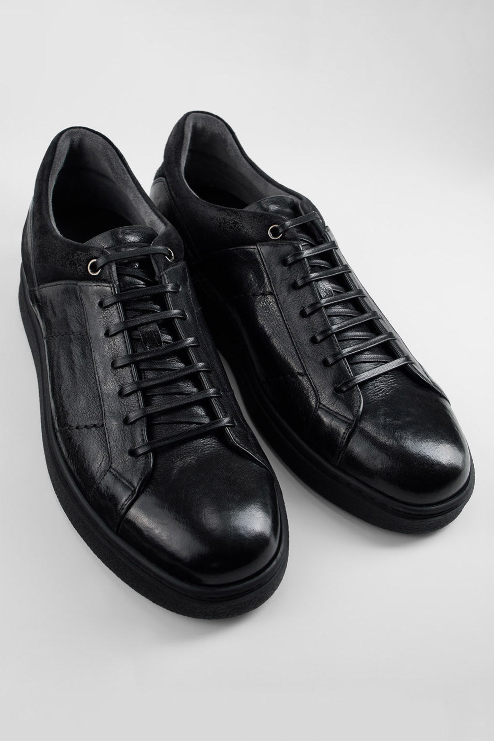 CREED jet-black distressed sneakers.