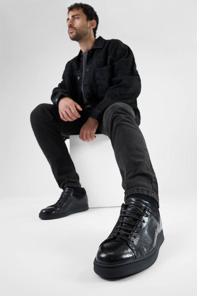 CREED jet-black distressed sneakers.