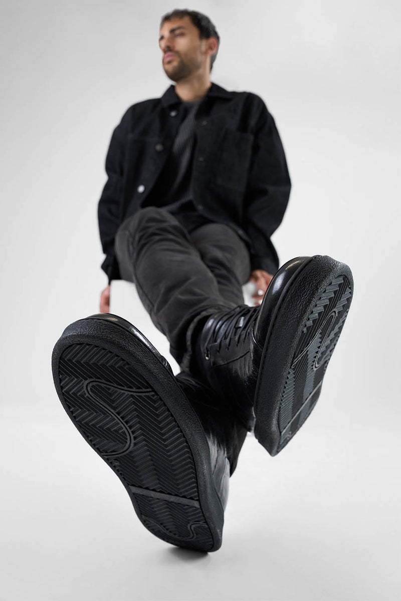 CREED jet-black distressed sneakers.