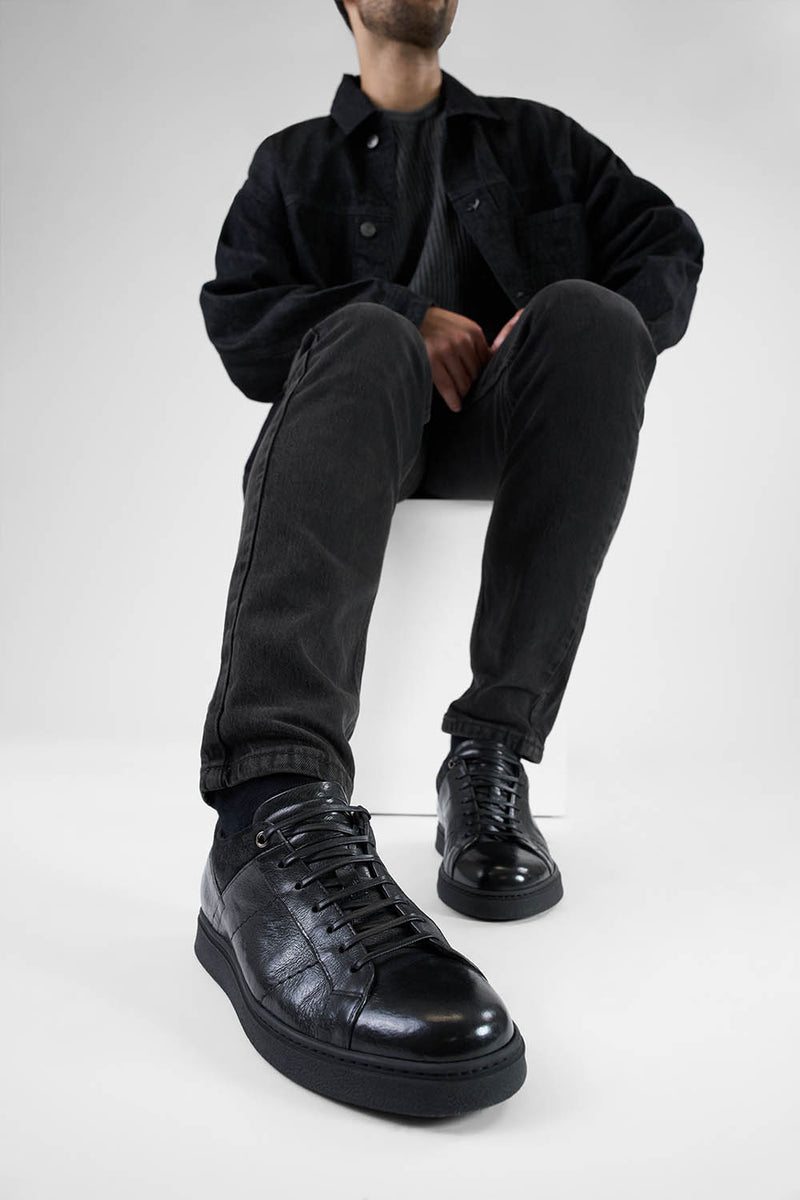 CREED jet-black distressed sneakers.