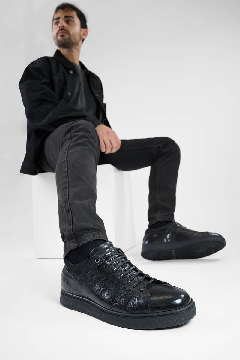 CREED jet-black distressed sneakers.
