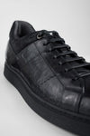 CREED jet-black distressed sneakers.
