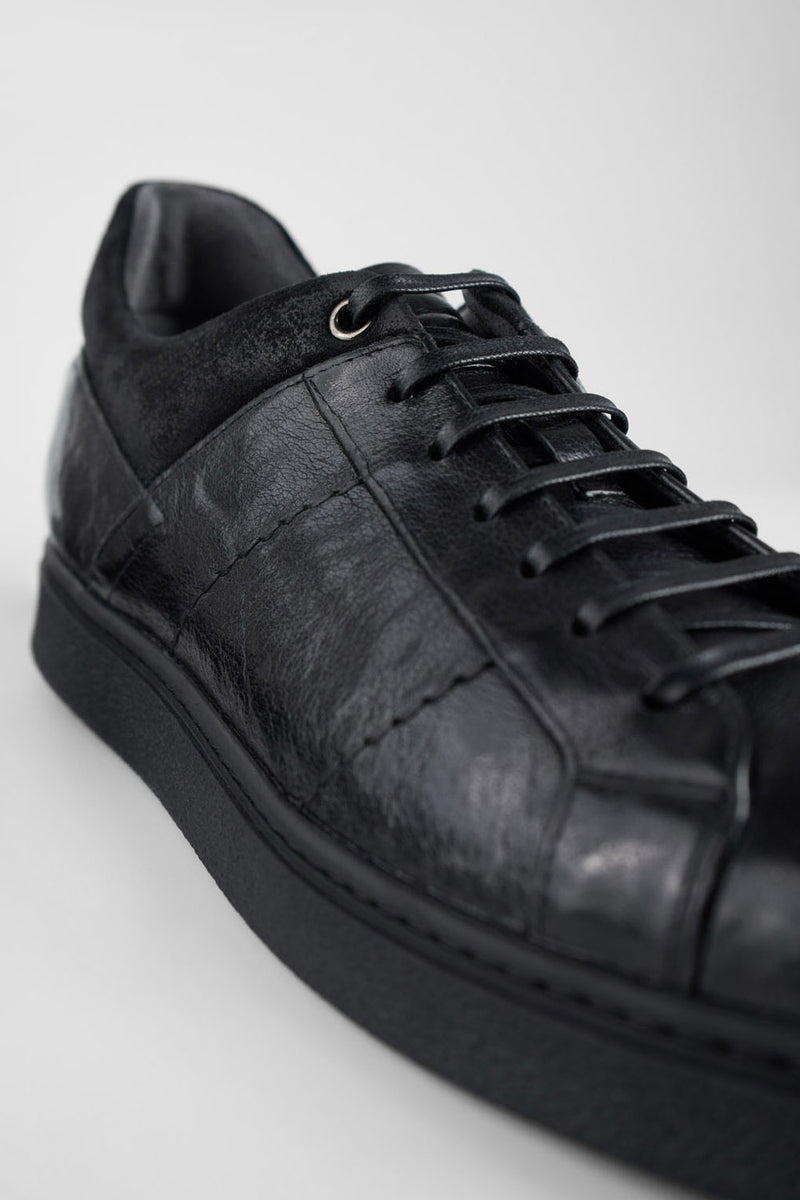 CREED jet-black distressed sneakers.