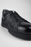 CREED jet-black distressed sneakers.
