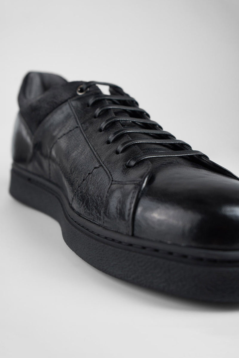 CREED jet-black distressed sneakers.