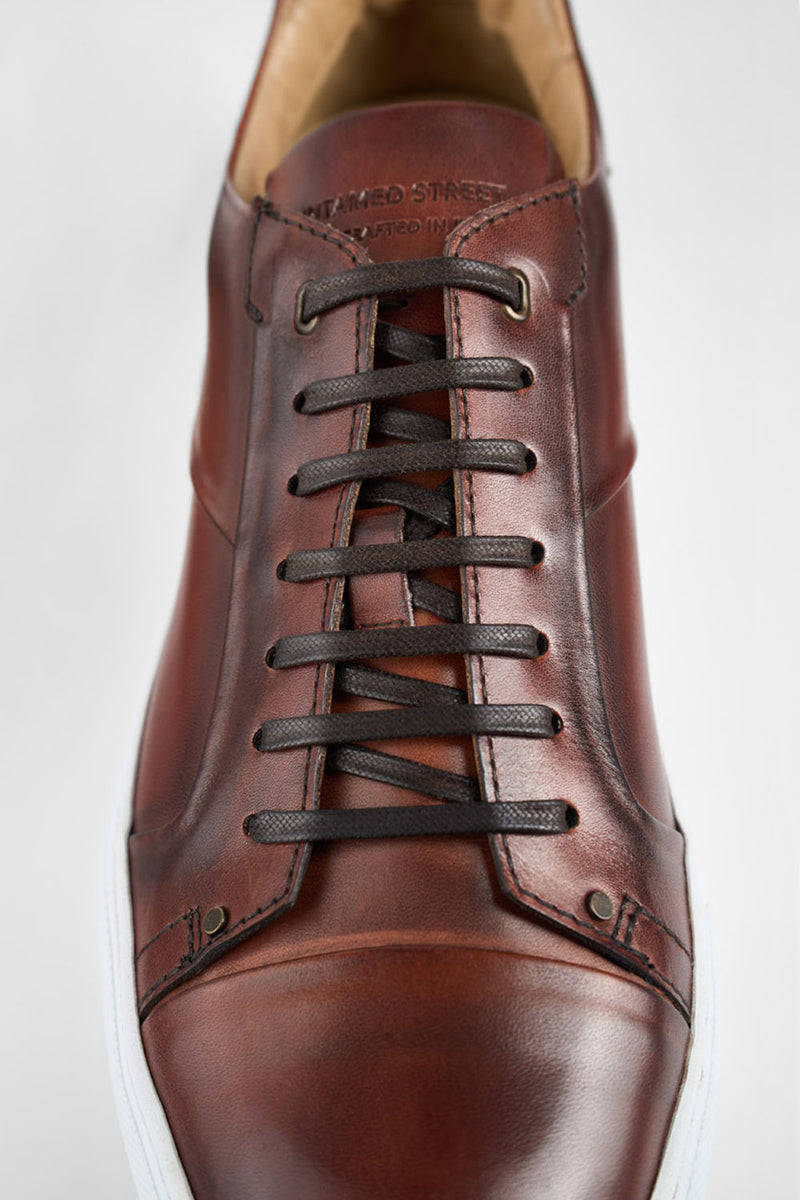 SKYE cognac studded patina sneakers.